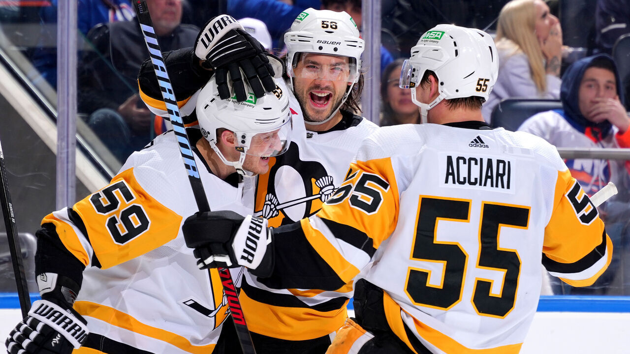 ELMONT, NEW YORK - DECEMBER 27: Jake Guentzel #59 of the Pittsburgh Penguins is congratulated by Kris Letang #58 and Noel Acciari #55 after scoring a goal against the New York Islanders during the second period at UBS Arena on December 27, 2023 in Elmont, New York.