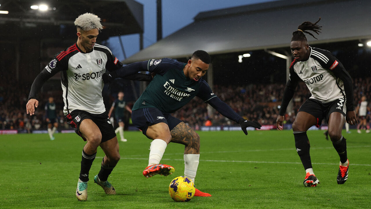 Arsenal's Brazilian striker #09 Gabriel Jesus (C) vies with Fulham's English-born US defender #33 Antonee Robinson (L) and Fulham's Italian-born Nigerian defender #03 Calvin Bassey (R) during the English Premier League football match between Fulham and Arsenal at Craven Cottage in London on December 31, 2023.