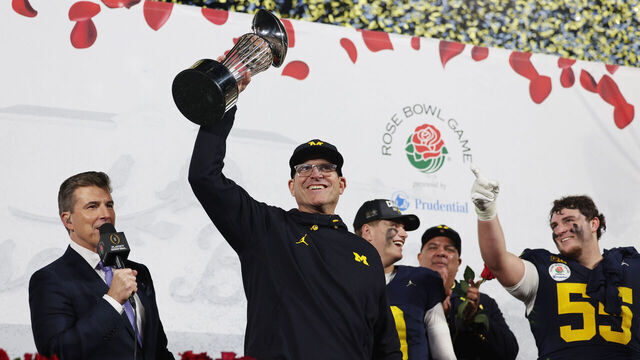 PASADENA, CALIFORNIA - JANUARY 01: Head coach Jim Harbaugh of the Michigan Wolverines celebrates with The Leishman Trophy after beating the Alabama Crimson Tide 27-20 in overtime to win the CFP Semifinal Rose Bowl Game at Rose Bowl Stadium on January 01, 2024 in Pasadena, California.