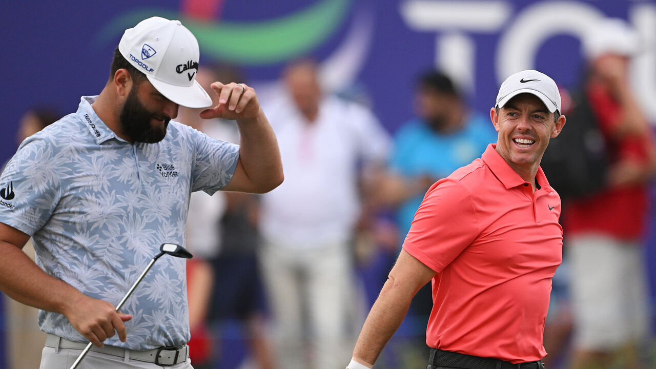 DUBAI, UNITED ARAB EMIRATES - NOVEMBER 16: Rory McIlroy of Northern Ireland smiles alongside Jon Rahm of Spain whilst leaving the 18th green during Day One of the DP World Tour Championship on the Earth Course at Jumeirah Golf Estates on November 16, 2023 in Dubai, United Arab Emirates.