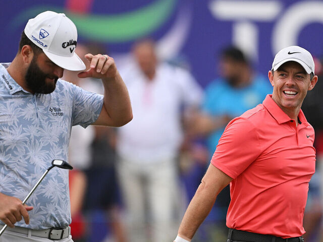 DUBAI, UNITED ARAB EMIRATES - NOVEMBER 16: Rory McIlroy of Northern Ireland smiles alongside Jon Rahm of Spain whilst leaving the 18th green during Day One of the DP World Tour Championship on the Earth Course at Jumeirah Golf Estates on November 16, 2023 in Dubai, United Arab Emirates.