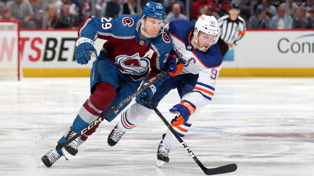 DENVER, COLORADO - APRIL 11: Nathan MacKinnon #29 of the Colorado Avalanche skates against Connor McDavid #97 of the Edmonton Oilers at Ball Arena on April 11, 2023 in Denver, Colorado.