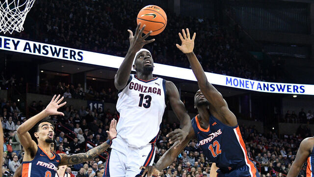 SPOKANE, WA - JANUARY 4: Graham Ike #13 of the Gonzaga Bulldogs catches an entry pass as Houston Mallette and Boubacar Coulibaly #12 of the Pepperdine Waves defend during the first half against the Pepperdine Waves at Spokane Veterans Memorial Arena on January 4, 2024 in Spokane, Washington.