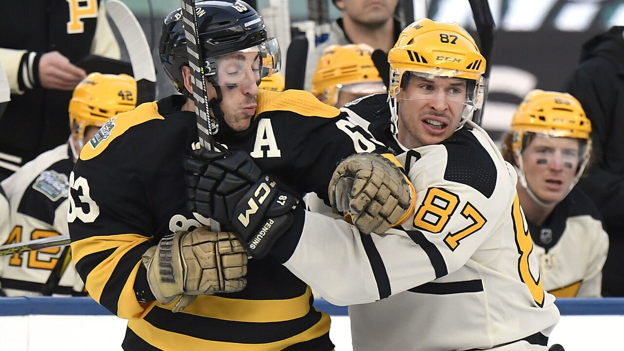 BOSTON, MASSACHUSETTS - JANUARY 02: Brad Marchand #63 of the Boston Bruins battles against Sidney Crosby #87 of the Pittsburgh Penguins during the first period of the 2023 Discover NHL Winter Classic at Fenway Park on January 02, 2023 in Boston, Massachusetts.