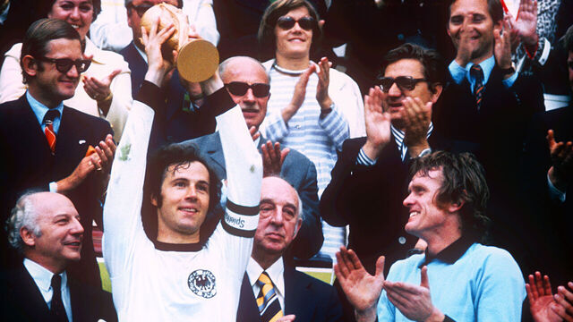 West Germany captain Franz Beckenbauer (left) lifts the World Cup as goalkeeper Sepp Maier (right) applauds