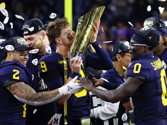 HOUSTON, TEXAS - JANUARY 08: J.J. McCarthy #9 of the Michigan Wolverines kisses the national championship trophy after defeating the Washington Huskies during the 2024 CFP National Championship game at NRG Stadium on January 08, 2024 in Houston, Texas. Michigan defeated Washington 34-13.