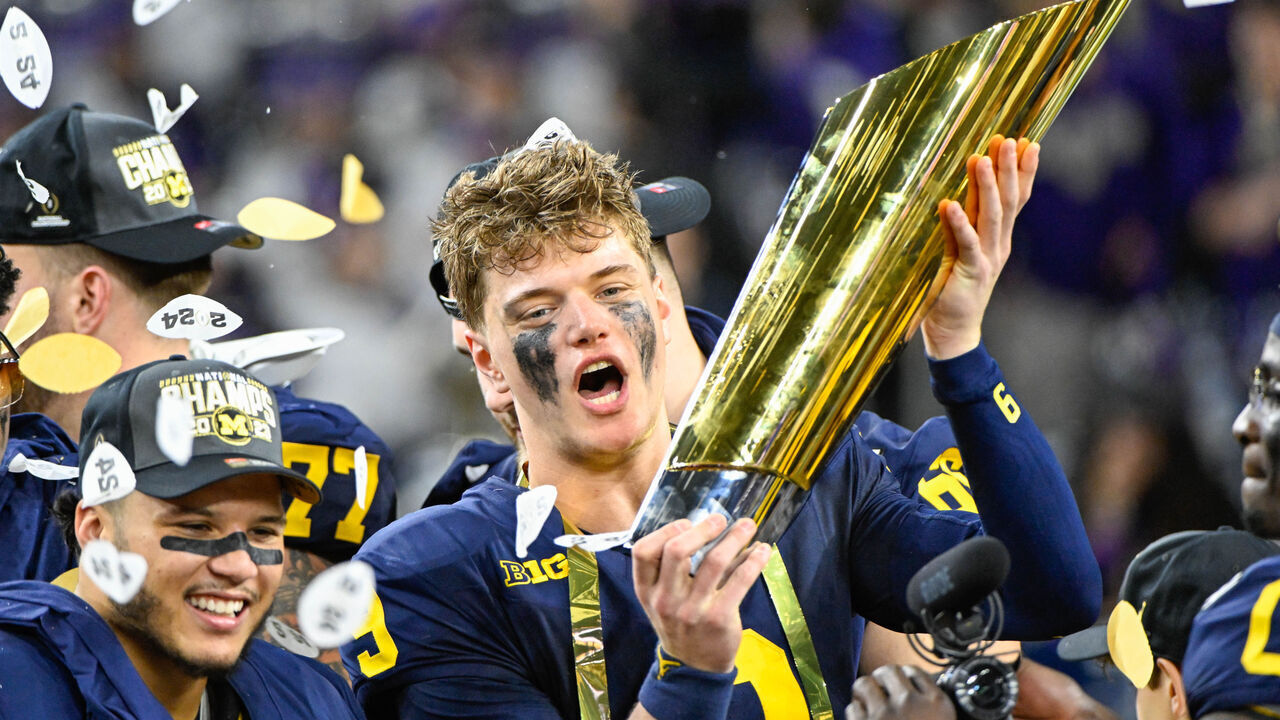 HOUSTON, TX - JANUARY 08: Michigan Wolverines quarterback J.J. McCarthy (9) celebrates with the trophy for winning the CFP National Championship football game between the Washington Huskies and Michigan Wolverines at NRG Stadium on January 8, 2024 in Houston, Texas.