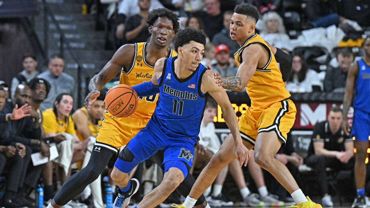 WICHITA, KS - JANUARY 14: Jahvon Quinerly #11 of the Memphis Tigers drives with the ball against Xavier Bell #1 of the Wichita State Shockers at Charles Koch Arena on January 14, 2024 in Wichita, Kansas.