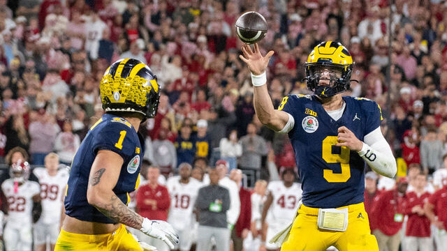 PASADENA, CALIFORNIA - JANUARY 01: J.J. McCarthy #9 of the Michigan Wolverines throws a pass to Roman Wilson #1 for a touchdown during the second half of the CFP Semifinal Rose Bowl Game against the Alabama Crimson Tide at Rose Bowl Stadium on January 01, 2024 in Pasadena, California. The Michigan Wolverines won the game 27-20 in overtime.