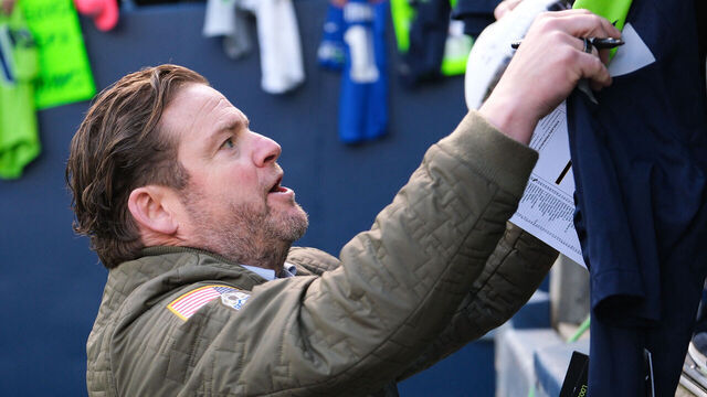 SEATTLE, WASHINGTON - DECEMBER 31: John Schneider general manager of the Seattle Seahawks signs autographs prior to a game against the Pittsburgh Steelers at Lumen Field on December 31, 2023 in Seattle, Washington.