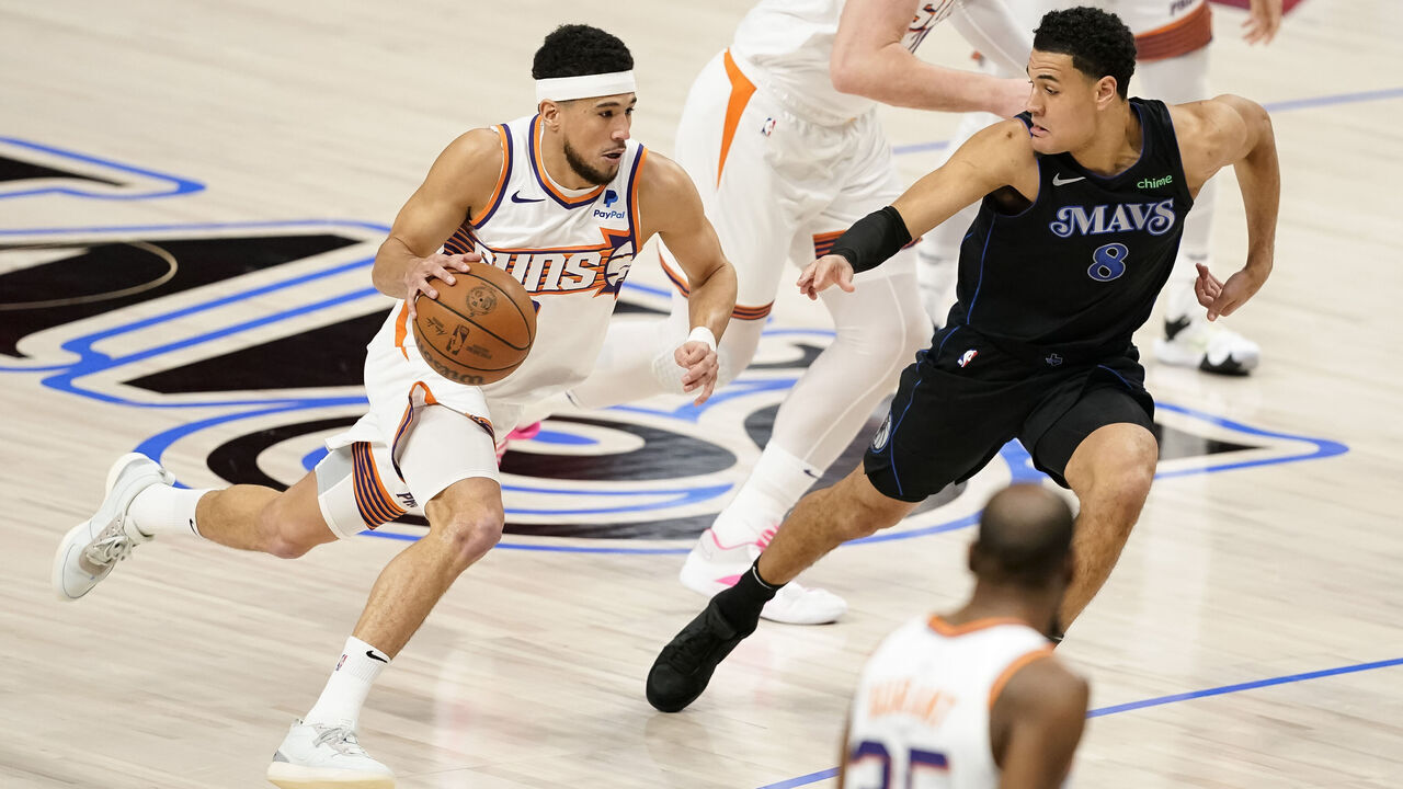 DALLAS, TEXAS - JANUARY 24: Devin Booker #1 of the Phoenix Suns drives with the ball as Josh Green #8 of the Dallas Mavericks defends during the first half at American Airlines Center on January 24, 2024 in Dallas, Texas.