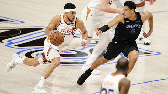 DALLAS, TEXAS - JANUARY 24: Devin Booker #1 of the Phoenix Suns drives with the ball as Josh Green #8 of the Dallas Mavericks defends during the first half at American Airlines Center on January 24, 2024 in Dallas, Texas.
