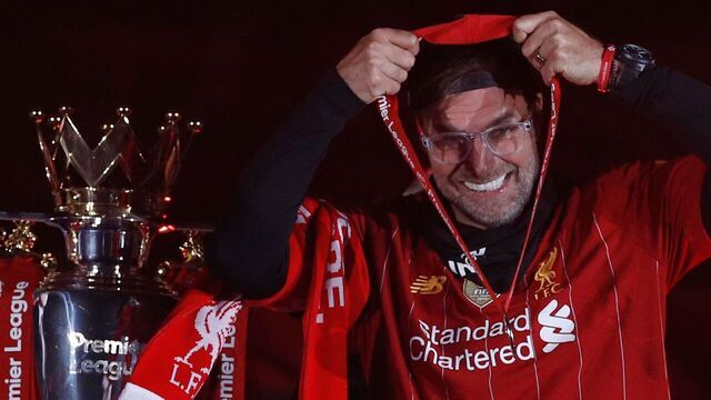 Liverpool's German manager Jurgen Klopp recieves his medal next to the Premier League trophy during the presentation following the English Premier League football match between Liverpool and Chelsea at Anfield in Liverpool, north west England on July 22, 2020. - Liverpool on Wednesday lifted the Premier League trophy at the famous Kop stand at Anfield after their final home game of the season. With no fans able to attend due to the COVID-19 coronavirus pandemic, Liverpool said the idea for the trophy lift was to honour the club's fans, but Liverpool manager Jurgen Klopp urged fans to respect social distancing measures, after thousands gathered around the club's stadium and in the city centre following their coronation as champions last month.