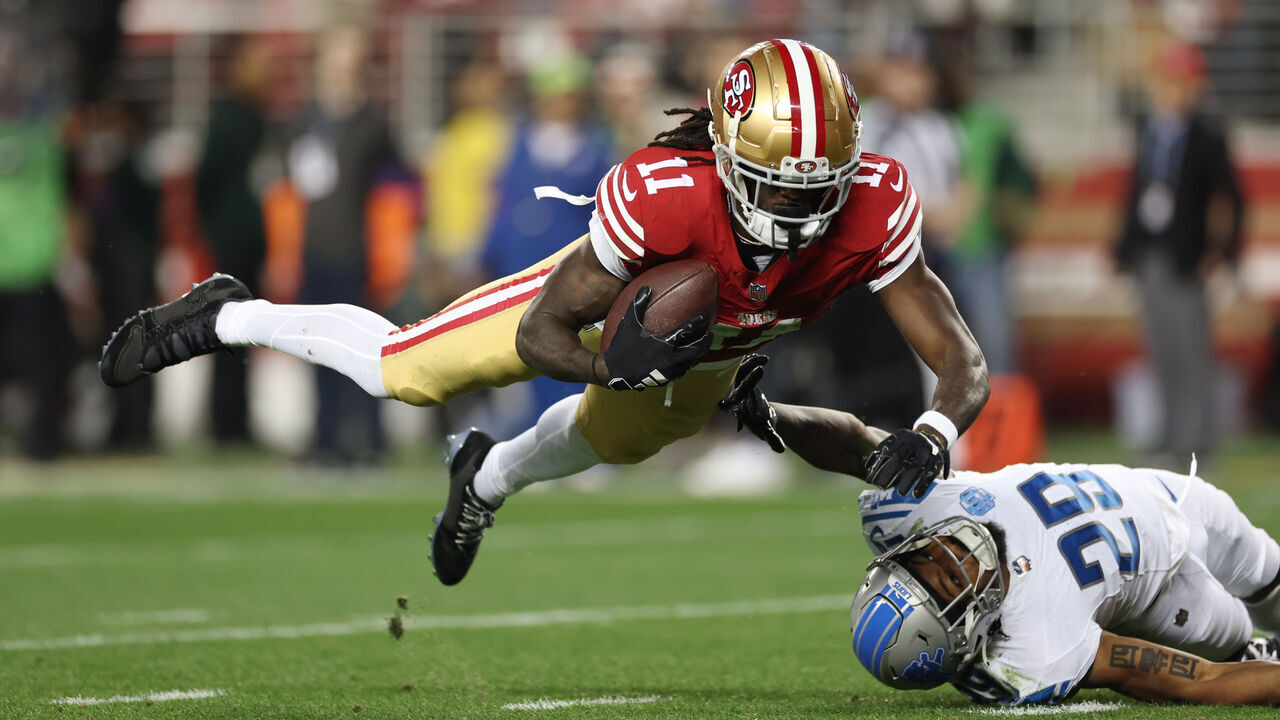 SANTA CLARA, CALIFORNIA - JANUARY 28: Brandon Aiyuk #11 of the San Francisco 49ers catches a pass that was tipped by Kindle Vildor #29 of the Detroit Lions during the third quarter in the NFC Championship Game at Levi's Stadium on January 28, 2024 in Santa Clara, California.