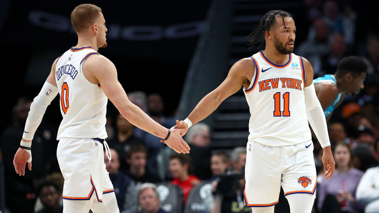 CHARLOTTE, NORTH CAROLINA - JANUARY 29: Donte DiVincenzo #0 and Jalen Brunson #11 of the New York Knicks react following a basket during the first half of the game against the Charlotte Hornets at Spectrum Center on January 29, 2024 in Charlotte, North Carolina.