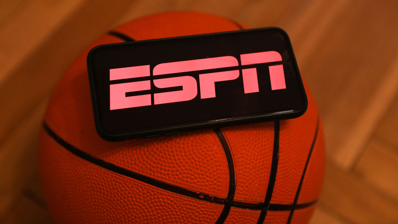ESPN logo displayed on a phone screen and a basketball are seen in this illustration photo taken in Krakow, Poland on December 1, 2022.