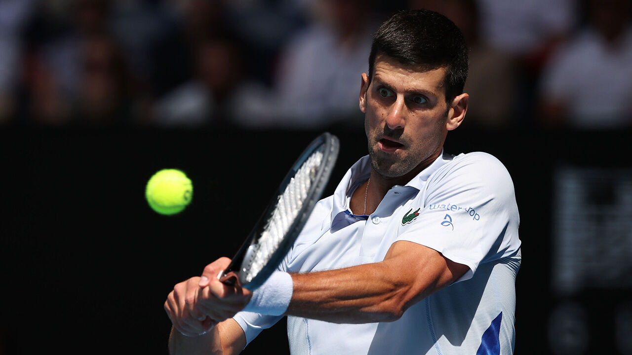 MELBOURNE, AUSTRALIA - JANUARY 26: Novak Djokovic of Serbia plays a backhand in their Semifinal singles match against Jannik Sinner of Italy during the 2024 Australian Open at Melbourne Park on January 26, 2024 in Melbourne, Australia.