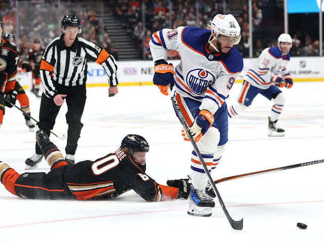 ANAHEIM, CALIFORNIA - FEBRUARY 09: Evander Kane #91 of the Edmonton Oilers skates past Jackson LaCombe #60 of the Anaheim Ducks and scores an empty net goal during the third period of a game at Honda Center on February 09, 2024 in Anaheim, California.