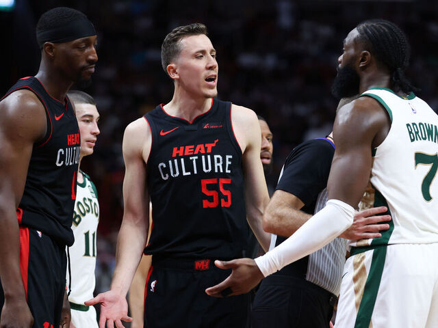 MIAMI, FLORIDA - FEBRUARY 11: Duncan Robinson #55 of the Miami Heat and Jaylen Brown #7 of the Boston Celtics exchange words on the court during the fourth quarter of the game at Kaseya Center on February 11, 2024 in Miami, Florida.