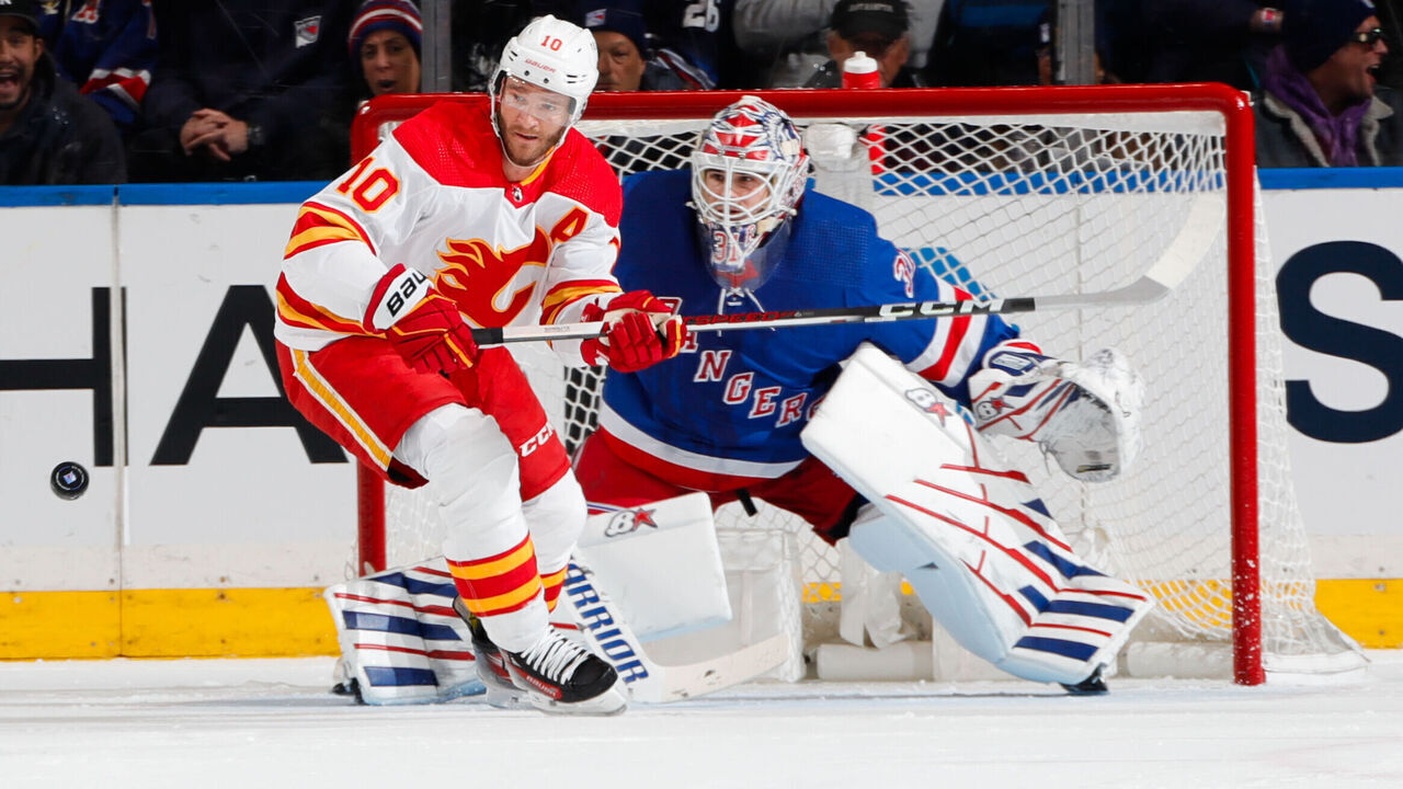 NEW YORK, NEW YORK - FEBRUARY 12: Jonathan Huberdeau #10 of the Calgary Flames skates with the puck against Igor Shesterkin #31 of the New York Rangers at Madison Square Garden on February 12, 2024 in New York City.