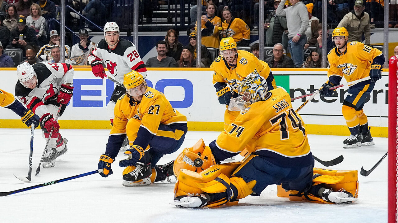 NASHVILLE, TENNESSEE - FEBRUARY 13: Juuse Saros #74 of the Nashville Predators makes a save against Curtis Lazar #42 of the New Jersey Devils during an NHL game at Bridgestone Arena on February 13, 2024 in Nashville, Tennessee.