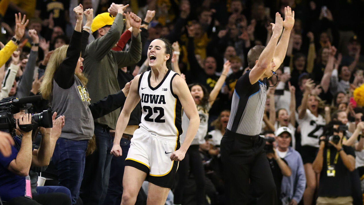 IOWA CITY, IOWA- FEBRUARY 15: Guard Caitlin Clark #22 of the Iowa Hawkeyes celebrates after breaking the NCAA women's all-time scoring record during the first half against the Michigan Wolverines at Carver-Hawkeye Arena on February 15, 2024 in Iowa City, Iowa.