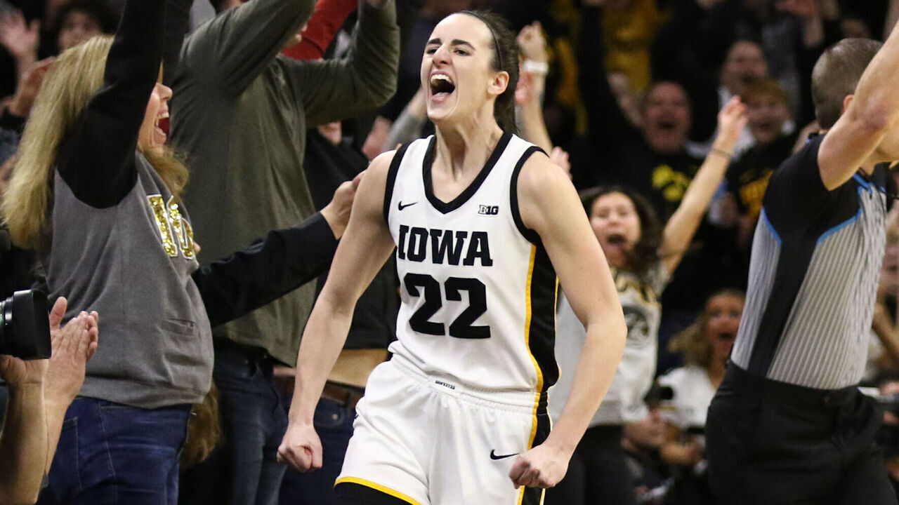 IOWA CITY, IOWA- FEBRUARY 15: Guard Caitlin Clark #22 of the Iowa Hawkeyes celebrates after breaking the NCAA women's all-time scoring record during the first half against the Michigan Wolverines at Carver-Hawkeye Arena on February 15, 2024 in Iowa City, Iowa.