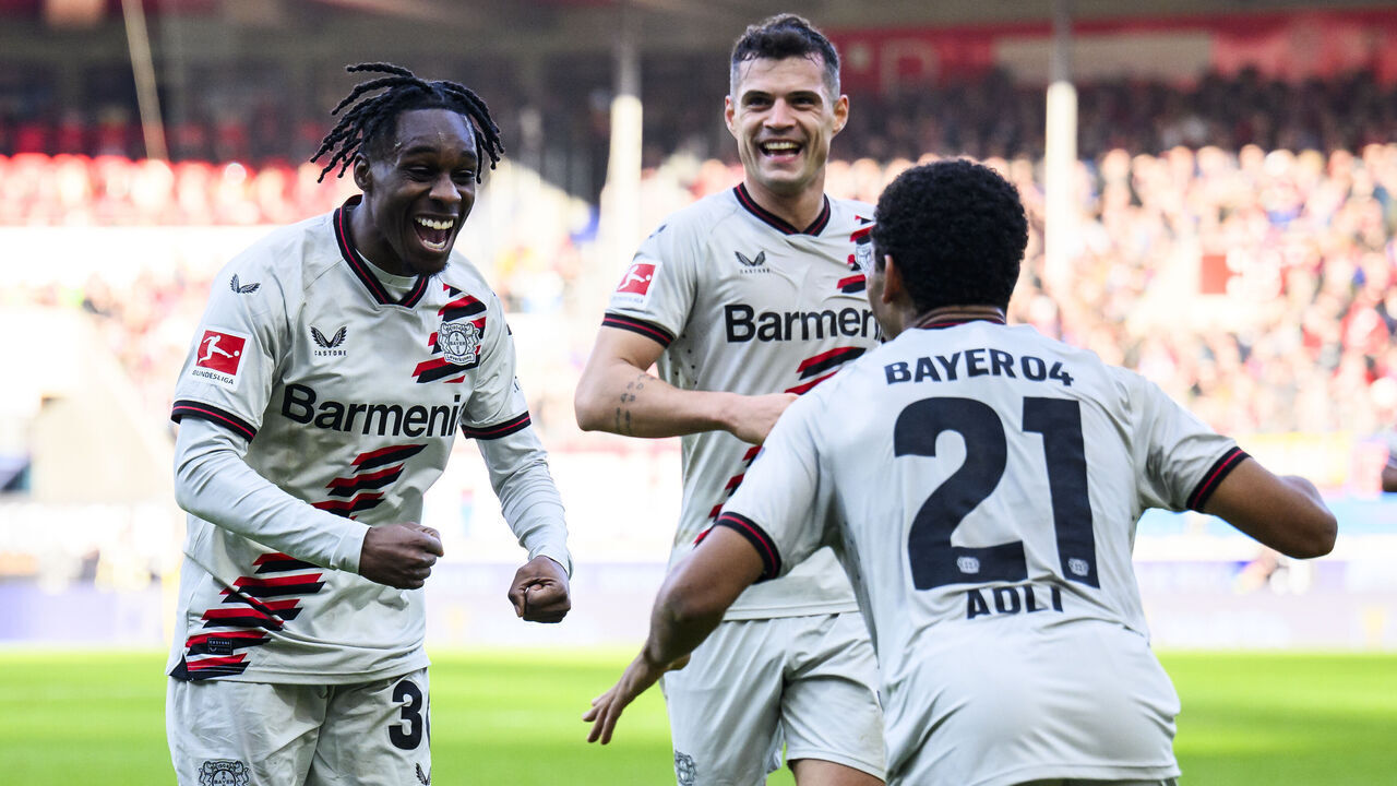17 February 2024, Baden-Württemberg, Heidenheim: Soccer: Bundesliga, 1. FC Heidenheim - Bayer Leverkusen, Matchday 22, Voith-Arena. Leverkusen's Jeremie Frimpong (l) celebrates after his goal for 0:1 with Leverkusen's Amine Adli (r) and Leverkusen's Granit Xhaka (M). Photo: Tom Weller/dpa - IMPORTANT NOTE: In accordance with the regulations of the DFL German Football League and the DFB German Football Association, it is prohibited to utilize or have utilized photographs taken in the stadium and/or of the match in the form of sequential images and/or video-like photo series.