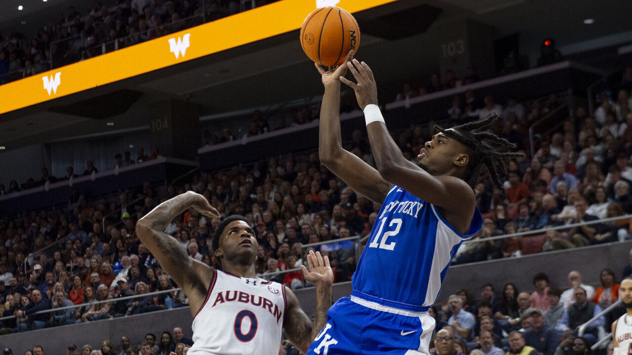 AUBURN, ALABAMA - FEBRUARY 17: Antonio Reeves #12 of the Kentucky Wildcats looks to take a shot over K.D. Johnson #0 of the Auburn Tigers during the first half of play at Neville Arena on February 17, 2024 in Auburn, Alabama.
