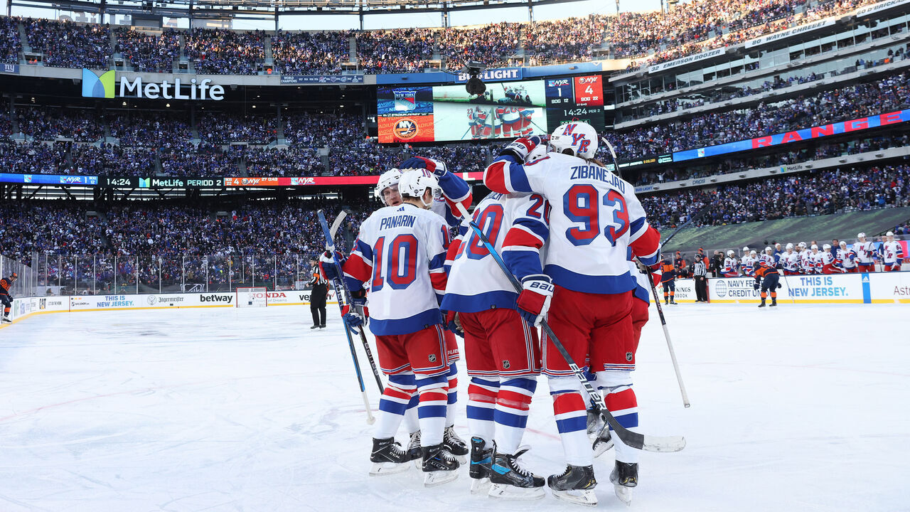 EAST RUTHERFORD, NEW JERSEY - FEBRUARY 18: Artemi Panarin #10 of the New York Rangers is congratulated by his teammates after scoring a goal against the New York Islanders during the second period during the 2024 Navy Federal Credit Union Stadium Series at MetLife Stadium on February 18, 2024 in East Rutherford, New Jersey.