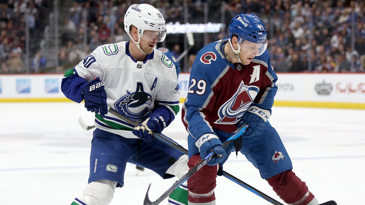 DENVER, COLORADO - FEBRUARY 20: Elias Pettersson #40 of the Vancouver Canucks fights for the puck against Nathan MacKinnon #29 of the Colorado Avalanche in the first period at Ball Arena on February 20, 2024 in Denver, Colorado.