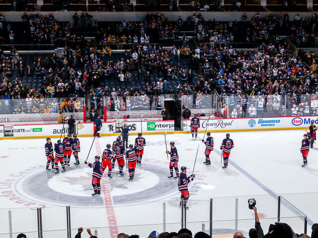 WINNIPEG, CANADA - DECEMBER 22: Winnipeg Jets players salute the fans following a 5-1 victory over the Boston Bruins at Canada Life Centre on December 22, 2023 in Winnipeg, Manitoba, Canada.