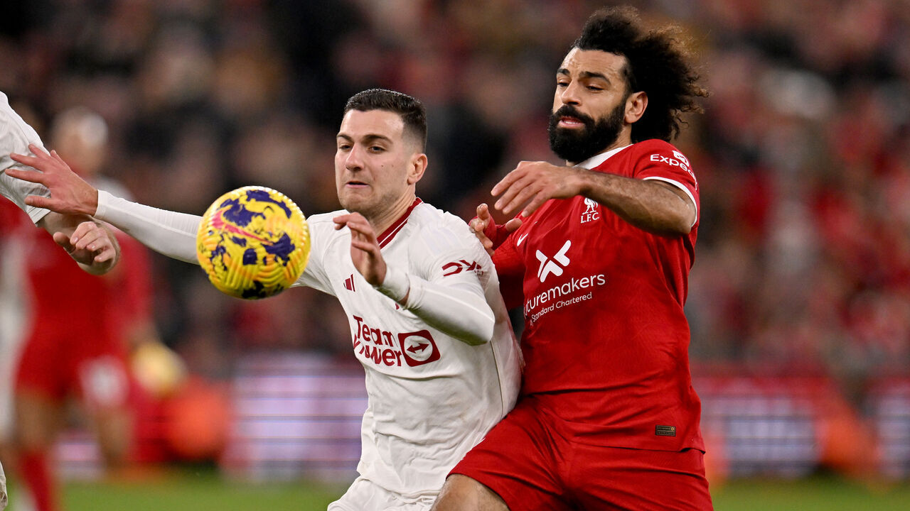 LIVERPOOL, ENGLAND - DECEMBER 17: (THE SUN OUT, THE SUN ON SUNDAY OUT) Mohamed Salah of Liverpool competing with Diogo Dalot of Manchester United during the Premier League match between Liverpool FC and Manchester United at Anfield on December 17, 2023 in Liverpool, England.