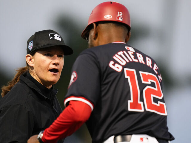 WEST PALM BEACH, FLORIDA - FEBRUARY 24: Umpire Jen Pawol shakes the hand of Washington Nationals third base coach Ricky Guiterrez #12 duringa spring training game against the Houston Astros at CACTI Park of the Palm Beaches on February 24, 2024 in West Palm Beach, Florida.