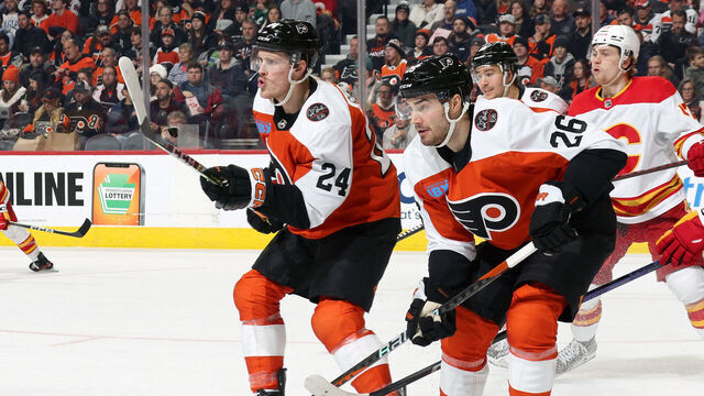 PHILADELPHIA, PENNSYLVANIA - JANUARY 06: Nick Seeler #24, Sean Walker #26 and Bobby Brink #10 of the Philadelphia Flyers defend Connor Zary #47 of the Calgary Flames at the Wells Fargo Center on January 6, 2024 in Philadelphia, Pennsylvania.