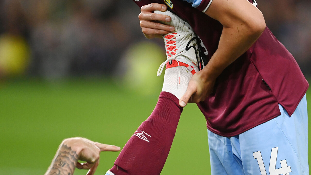 BURNLEY, ENGLAND - AUGUST 11: Connor Roberts of Burnley treats a team mate with cramp during the Premier League match between Burnley FC and Manchester City at Turf Moor on August 11, 2023 in Burnley, England.