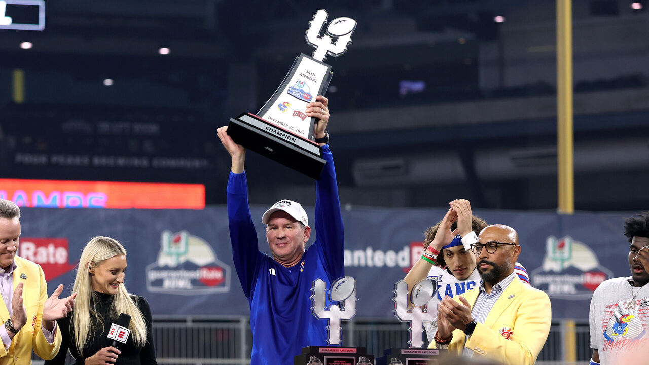 PHOENIX, AZ - DECEMBER 26: Kansas Jayhawks head coach Lance Leipold hoist the Guarantee Rate Bowl game trophy after a victory at the Guaranteed Rate Bowl college football game between the Kansas Jayhawks and the UNLV Rebels on December 26, 2023, at Chase Field in Phoenix, AZ.