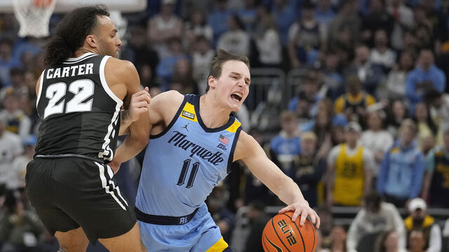 MILWAUKEE, WISCONSIN - FEBRUARY 28: Tyler Kolek #11 of the Marquette Golden Eagles dribbles the ball against Devin Carter #22 of the Providence Friars during the first half at Fiserv Forum on February 28, 2024 in Milwaukee, Wisconsin.