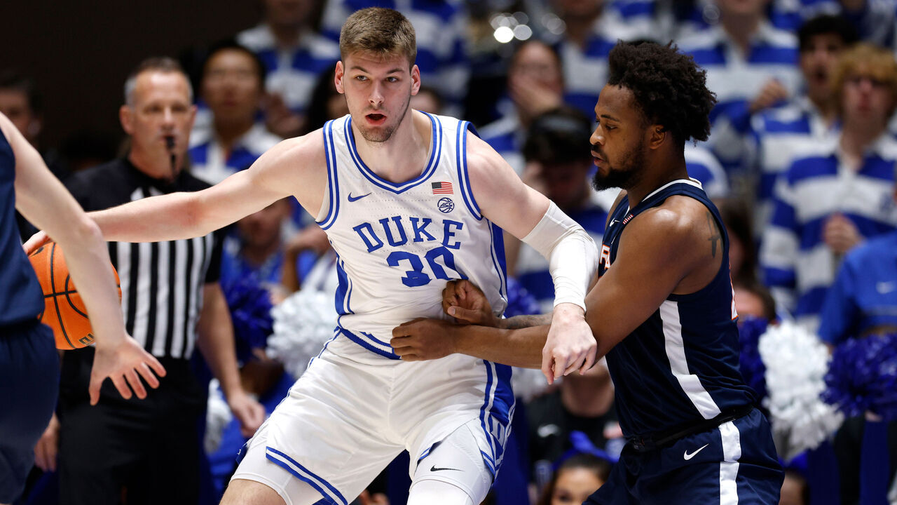 DURHAM, NORTH CAROLINA - MARCH 2: Kyle Filipowski #30 of the Duke Blue Devils moves the ball against Jordan Minor #22 of the Virginia Cavaliers during the first half of the game at Cameron Indoor Stadium on March 2, 2024 in Durham, North Carolina.