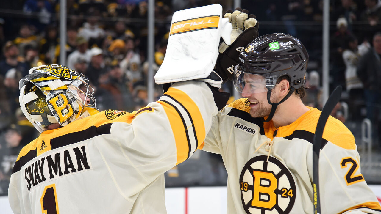 BOSTON, MASSACHUSETTS - MARCH 7: Jeremy Swayman #1 and Brandon Carlo #25 of the Boston Bruins high five after the win against the Toronto Maple Leafs at the TD Garden on March 7, 2024 in Boston, Massachusetts.
