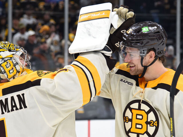BOSTON, MASSACHUSETTS - MARCH 7: Jeremy Swayman #1 and Brandon Carlo #25 of the Boston Bruins high five after the win against the Toronto Maple Leafs at the TD Garden on March 7, 2024 in Boston, Massachusetts.
