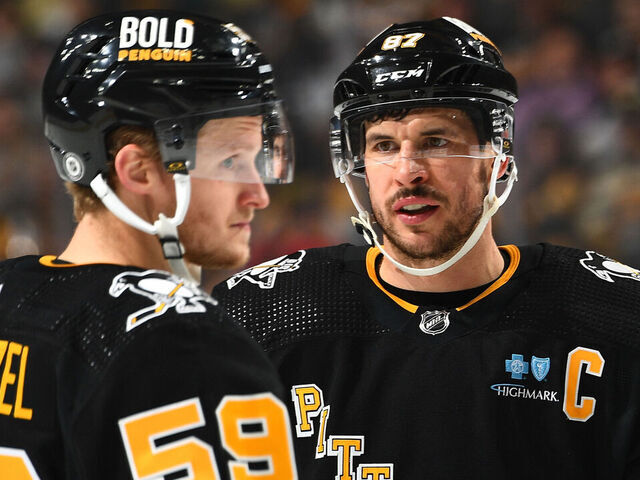 PITTSBURGH, PA - NOVEMBER 16: Sidney Crosby #87 talks with Jake Guentzel #59 of the Pittsburgh Penguins during the game against the New Jersey Devils at PPG PAINTS Arena on November 16, 2023 in Pittsburgh, Pennsylvania.