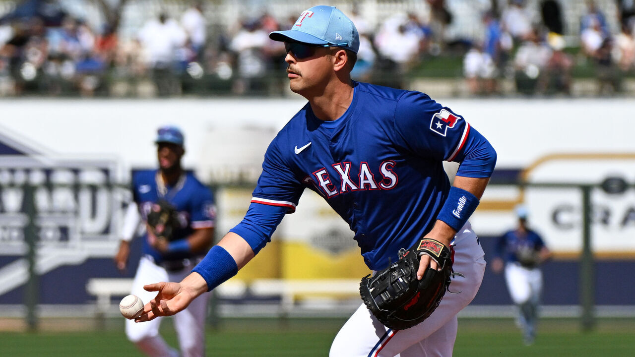 SURPRISE, ARIZONA - FEBRUARY 28, 2024: Nathaniel Lowe #30 of the Texas Rangers throws to first base during the third inning of a spring training game against the Los Angeles Dodgers at Surprise Stadium on February 28, 2024 in Surprise, Arizona.