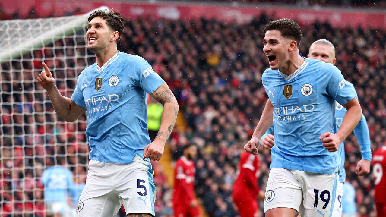LIVERPOOL, ENGLAND - MARCH 10: John Stones of Manchester City (L) celebrates scoring his team's first goal alongside teammate Julian Alvarez during the Premier League match between Liverpool FC and Manchester City at Anfield on March 10, 2024 in Liverpool, England.