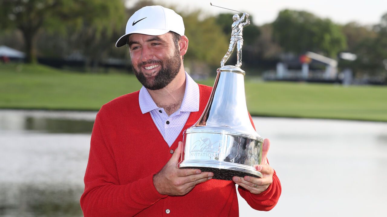 ORLANDO, FL - MARCH 10: PGA golfer Scottie Scheffler poses with the trophy and in the red cardigan sweater after winning the Arnold Palmer Invitational presented by MasterCard at the Arnold Palmer's Bay Hill Club & Lodge on March 10, 2024, in Orlando, Florida.