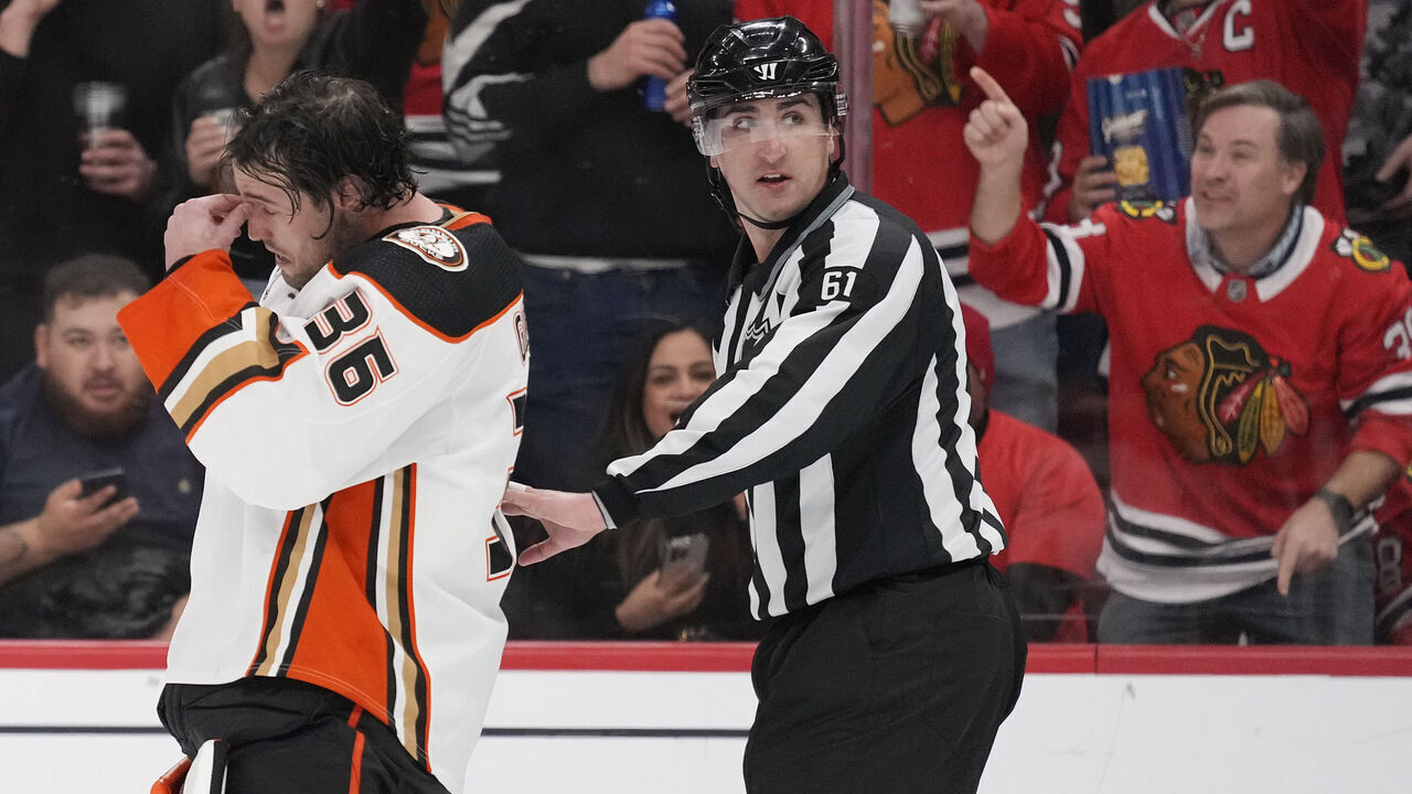 CHICAGO, ILLINOIS - MARCH 12: Linesman James Tobias #61 escorts John Gibson #36 of the Anaheim Ducks to the bench after receiving a misconduct penalty during the third period against the Chicago Blackhawks at the United Center on March 12, 2024 in Chicago, Illinois.