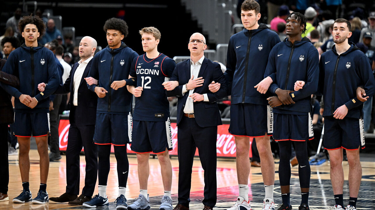 WASHINGTON, DC - FEBRUARY 10: Cam Spencer #12, head coach Dan Hurley and Donovan Clingan #32 of the Connecticut Huskies stand for the national anthem before the game against the Georgetown Hoyas at Capital One Arena on February 10, 2024 in Washington, DC.