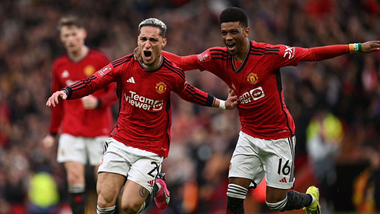 Manchester United's Brazilian midfielder #21 Antony (L) celebrates with Manchester United's Ivorian midfielder #16 Amad Diallo (R) after scoring their second goal during the English FA Cup Quarter Final football match between Manchester United and Liverpool at Old Trafford in Manchester, north west England, on March 17, 2024.