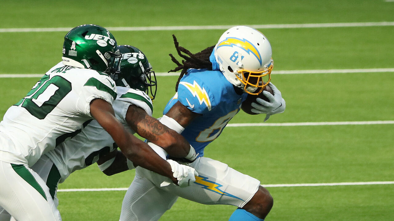 INGLEWOOD, CALIFORNIA - NOVEMBER 22: Mike Williams #81 of the Los Angeles Chargers breaks away from a tackle from Arthur Maulet #23 and Marcus Maye #20 of the New York Jets during the second quarter at SoFi Stadium on November 22, 2020 in Inglewood, California.