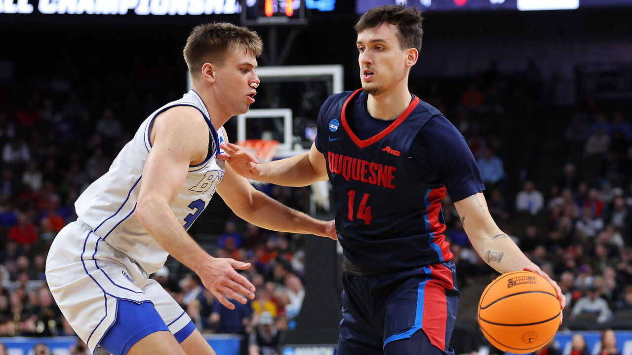 OMAHA, NEBRASKA - MARCH 21: Matus Hronsky #14 of the Duquesne Dukes drives the ball around Dallin Hall #30 of the Brigham Young Cougars in the first round of the NCAA Men's Basketball Tournament at CHI Health Center on March 21, 2024 in Omaha, Nebraska.